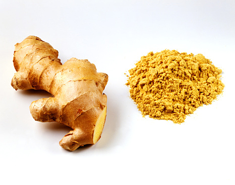 Fresh root ginger with pile of ginger powder